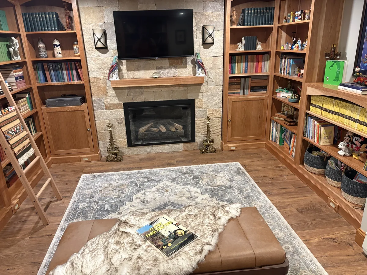 Custom wood shelving around a stone fireplace.
