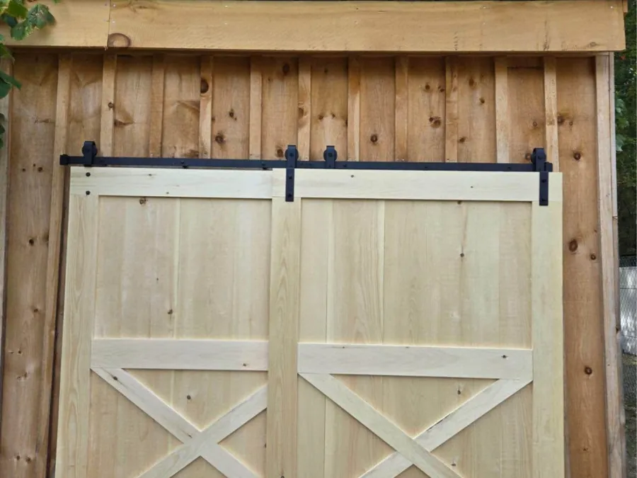 Sliding barn doors with white cross bracing and black track hardware.